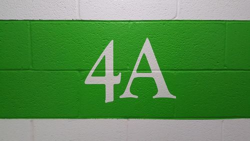 Close-up of text and number on green wall