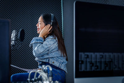 Side view of a young woman using mobile phone