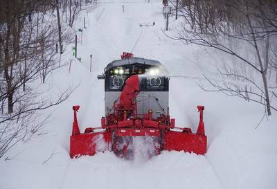 Snow removal train running while blowing snow away