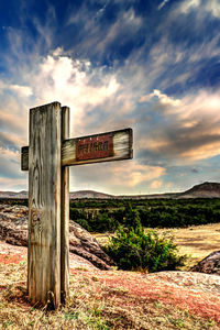 Wooden posts on field against sky