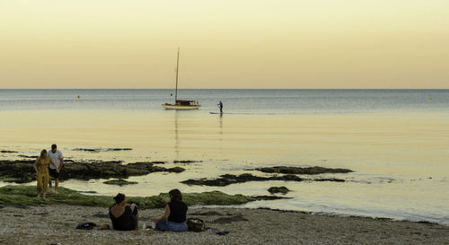 People at beach during sunset