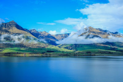 Scenic view of lake and mountains against sky