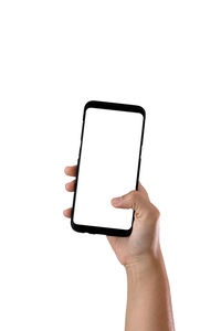 Close-up of hand holding smart phone over white background