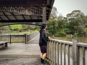 Rear view of man standing on footbridge