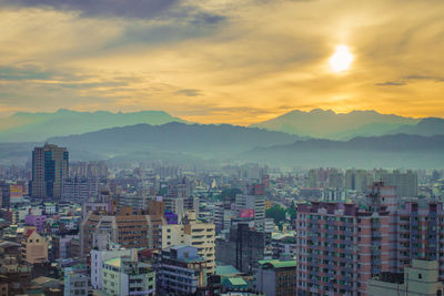 Aerial view of city against cloudy sky