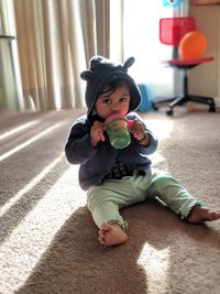 Portrait of cute baby girl sitting at home