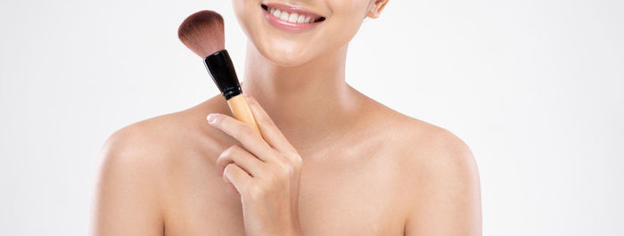 Portrait of a smiling young woman over white background