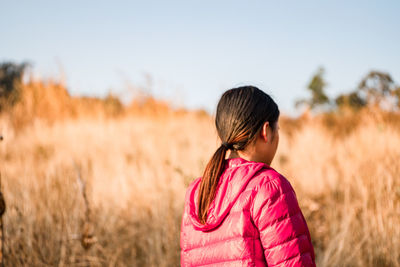 Rear view of woman walking on field