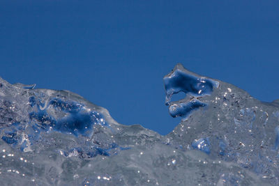 Close-up of ice crystals against clear blue sky