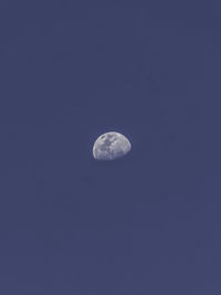 Low angle view of moon against blue sky at night