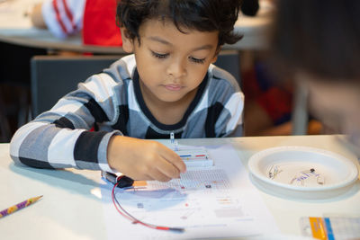 Cute boy studying at classroom