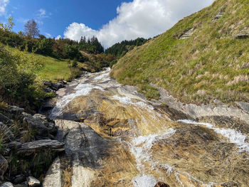 Scenic view of waterfall against sky