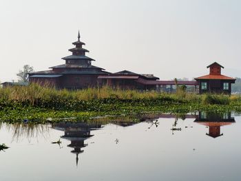 Built structure by lake against sky