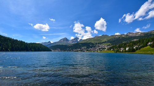 Scenic view of lake and mountains against blue sky