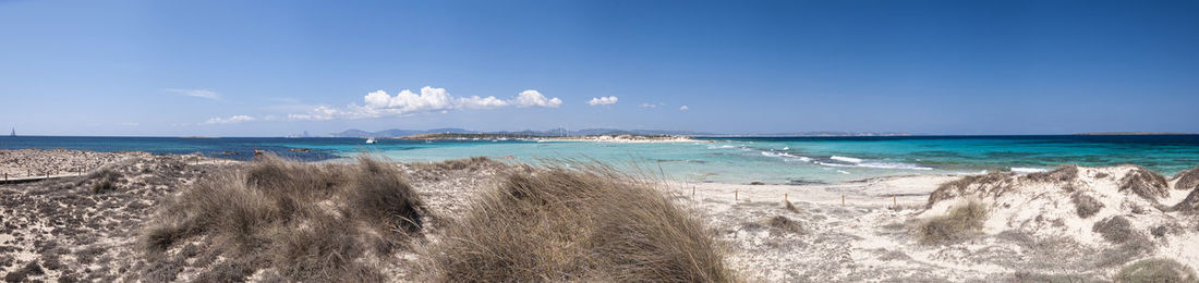 Big panoramic photo formentera espalmador beach. in the background sailboats anchored in the bay 