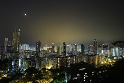 Illuminated cityscape against sky at night