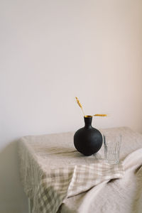 Modern dining table setting. a beautiful black vase with a linen napkin on the table.