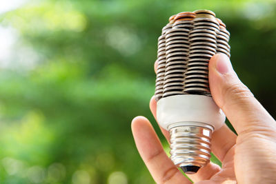 Midsection of woman holding coin bulb