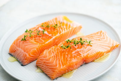 Fresh salmon fillet with herbs on a plate for delicious salmon steak.