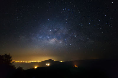 Silhouette mountain against star field at night