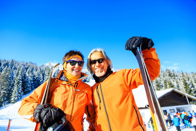 Portrait of friends standing against clear blue sky