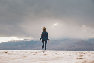 Full length of woman standing on mountain against sky