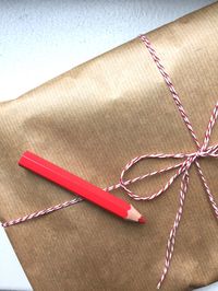 High angle view of gift and red pencil on table