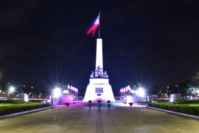 Statue in city at night