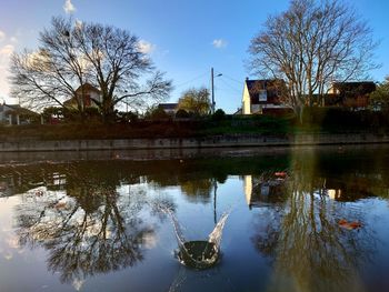 Reflection of building on lake against sky