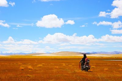 Man on motorcycle looking at hilly landscape