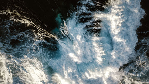 Aerial view of waves splashing in sea 