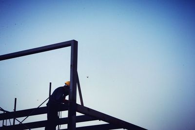 Low angle view of bird against clear blue sky