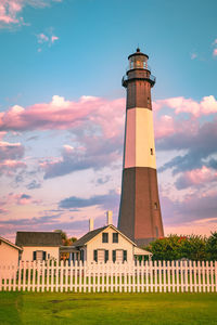 Low angle view of lighthouse by building against sky