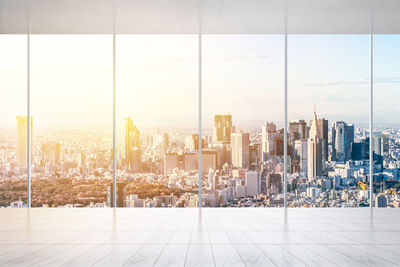 Modern buildings against sky seen through glass window