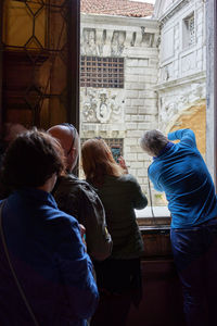 Rear view of people sitting outside building