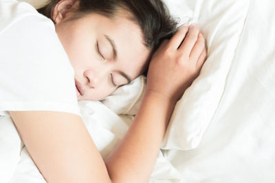 High angle view of baby sleeping on bed