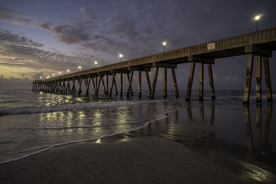 Pier over sea against sky during sunset