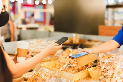 Female customer in protective mask make contactless mobile payment