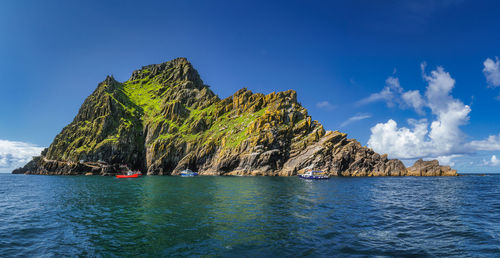 Panorama with cruise boats docking to skellig michael island, where star wars were filmed, ireland