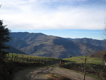 Road leading towards mountains against sky