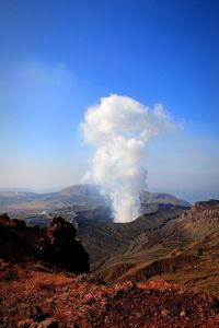 Smoke emitting from volcanic mountain against sky