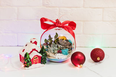 Close-up of christmas decoration on table against wall