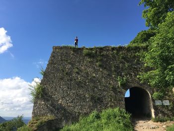 Low angle view of man on rock against sky