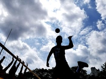 Low angle view of man playing with ball against sky