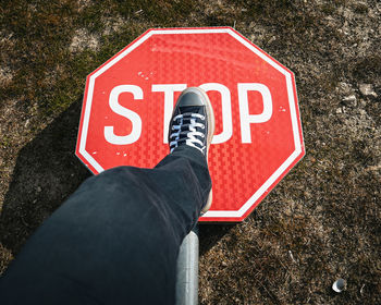 Low section of man standing on sign