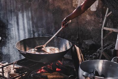 Midsection of person preparing food on barbecue grill