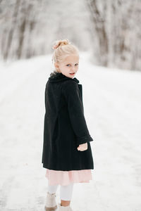 Portrait of young girl standing on snow
