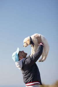 Low section of  man with dog against clear sky