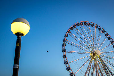 Low angle view of ferris wheel against blue sky