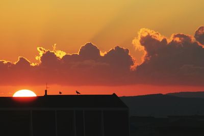 Silhouette of building against sky during sunset